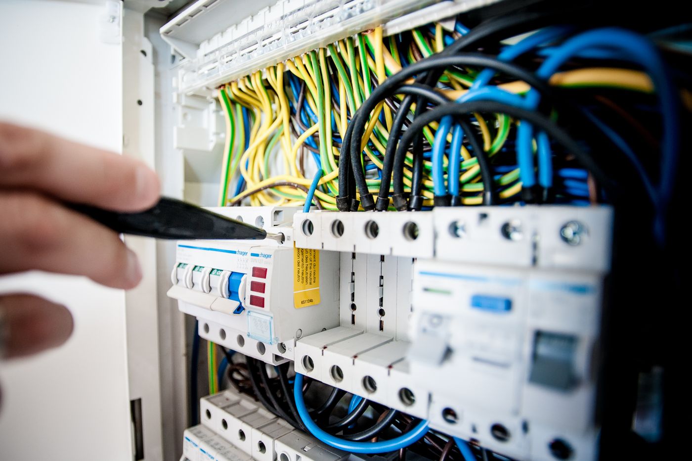 Electrician checking a home circuit breaker panel for a tripped 240-volt dryer circuit
